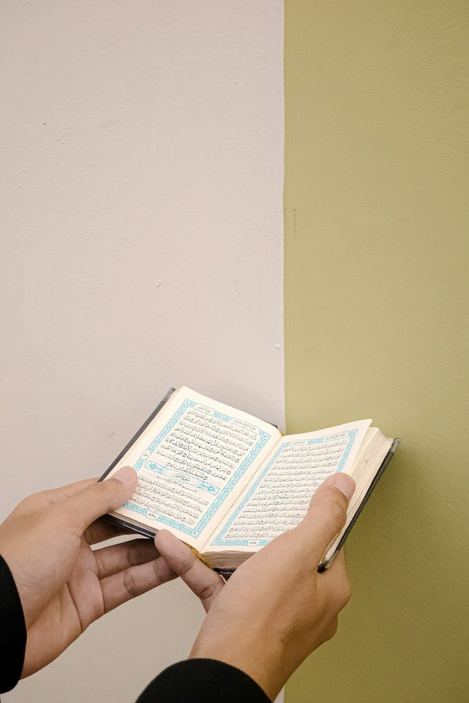 A person holding and reading Quran, learn via Online Noorani Qaida Course