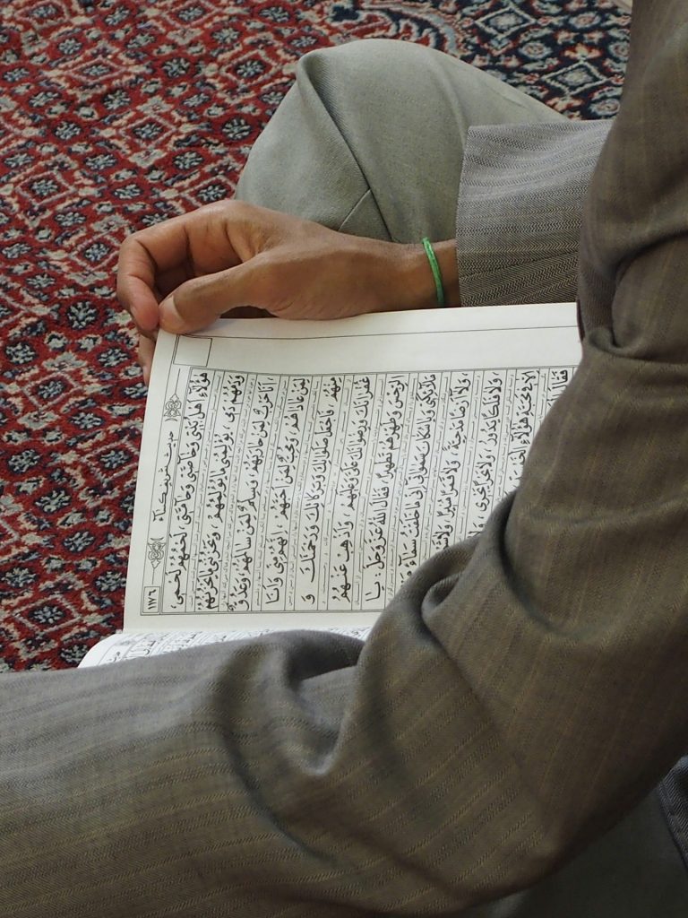 "A person holding and reading Quran, learn via Online Noorani Qaida Course